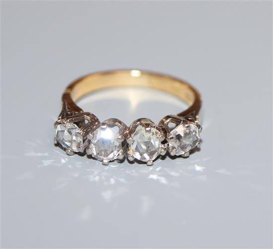 A continental 750 yellow metal and rose cut diamond set four stone half hoop ring, size K.